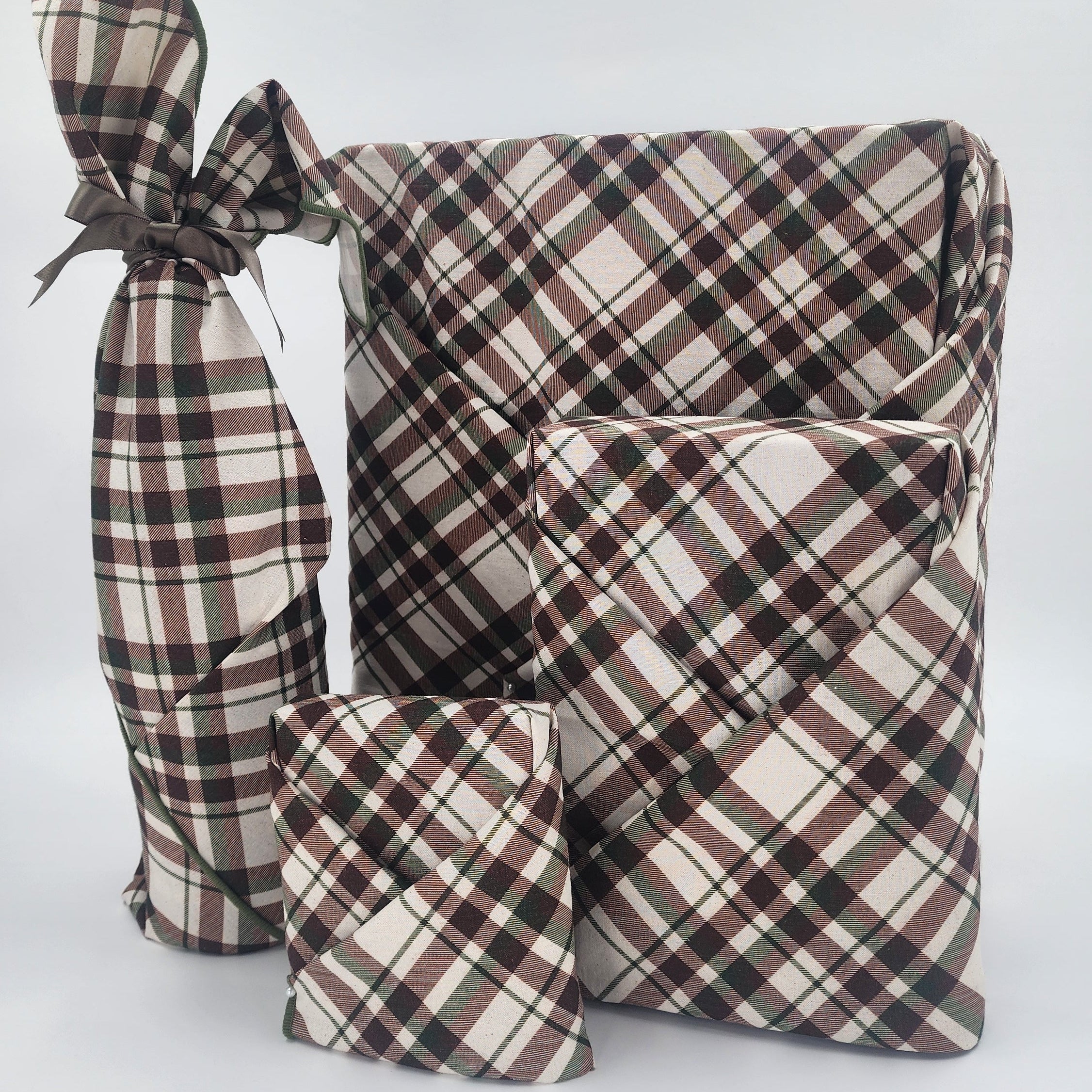 Furoshiki cotton gift wrap on on four gifts in brown and green tartan design