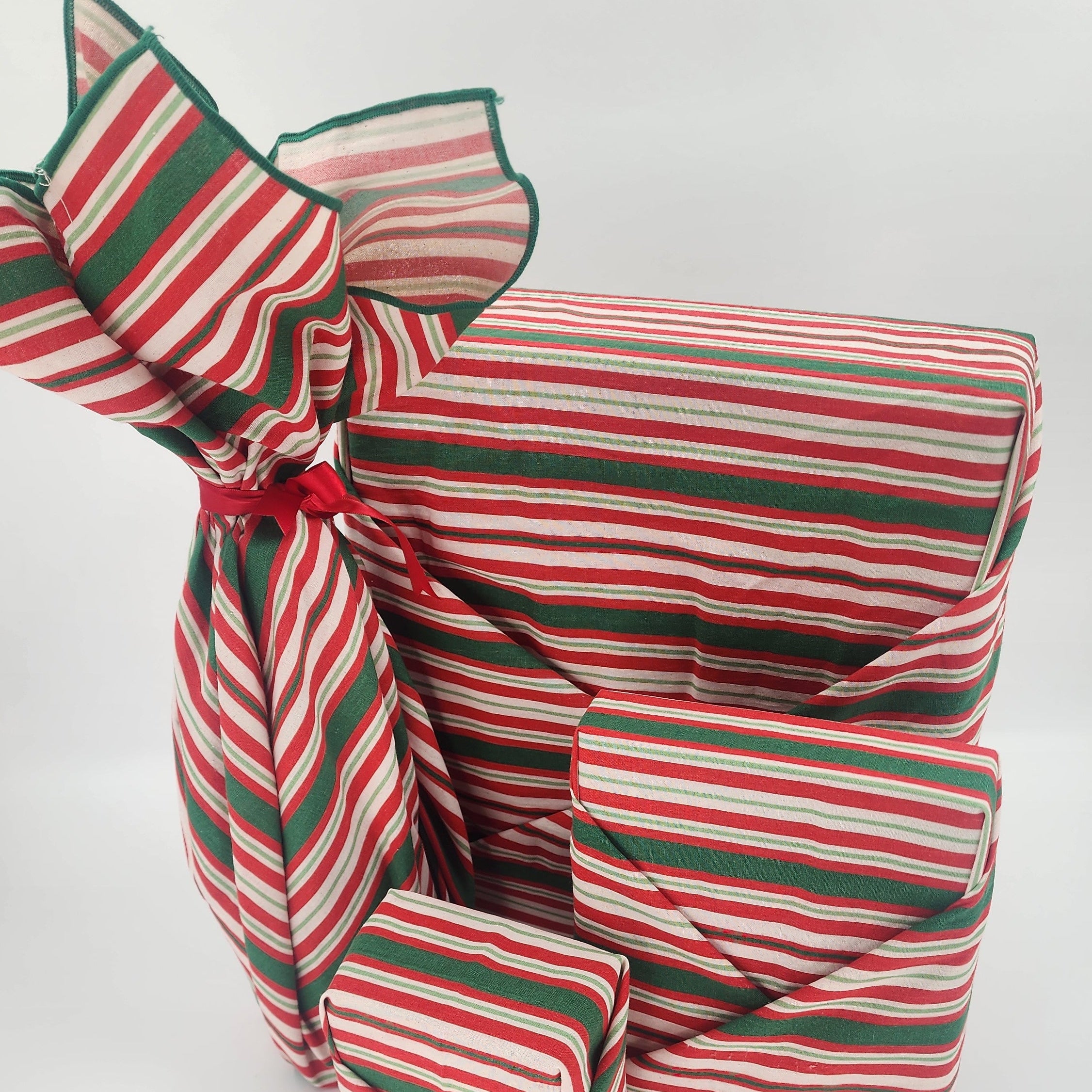 Furoshiki cotton gift wrap on on four gifts in red and green striped design