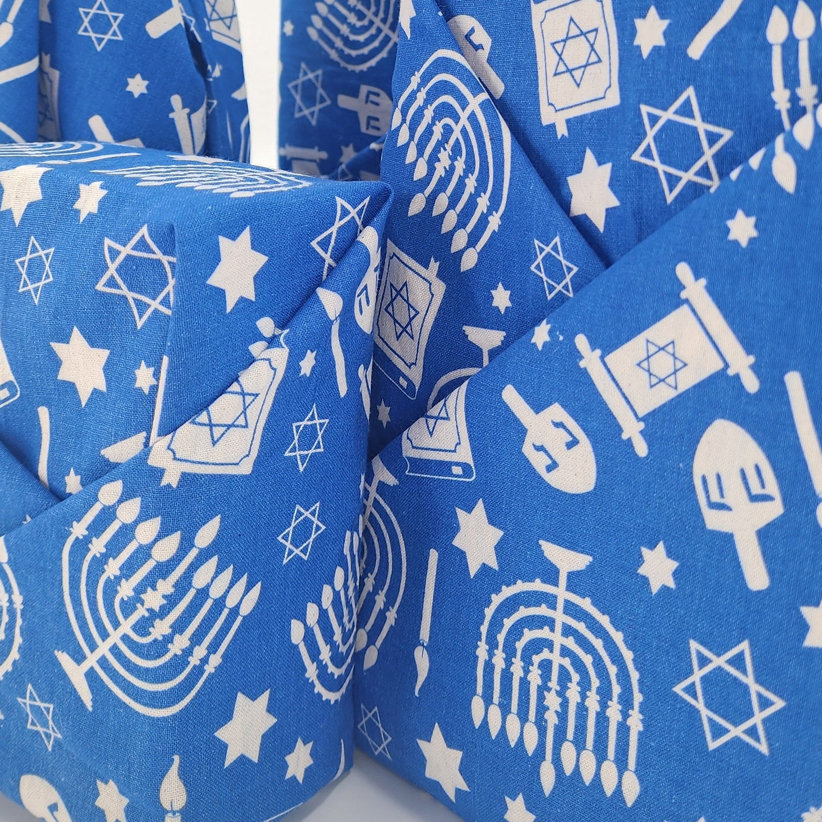 Furoshiki cotton gift wrap on on four gifts in blue and white Hanukkah design