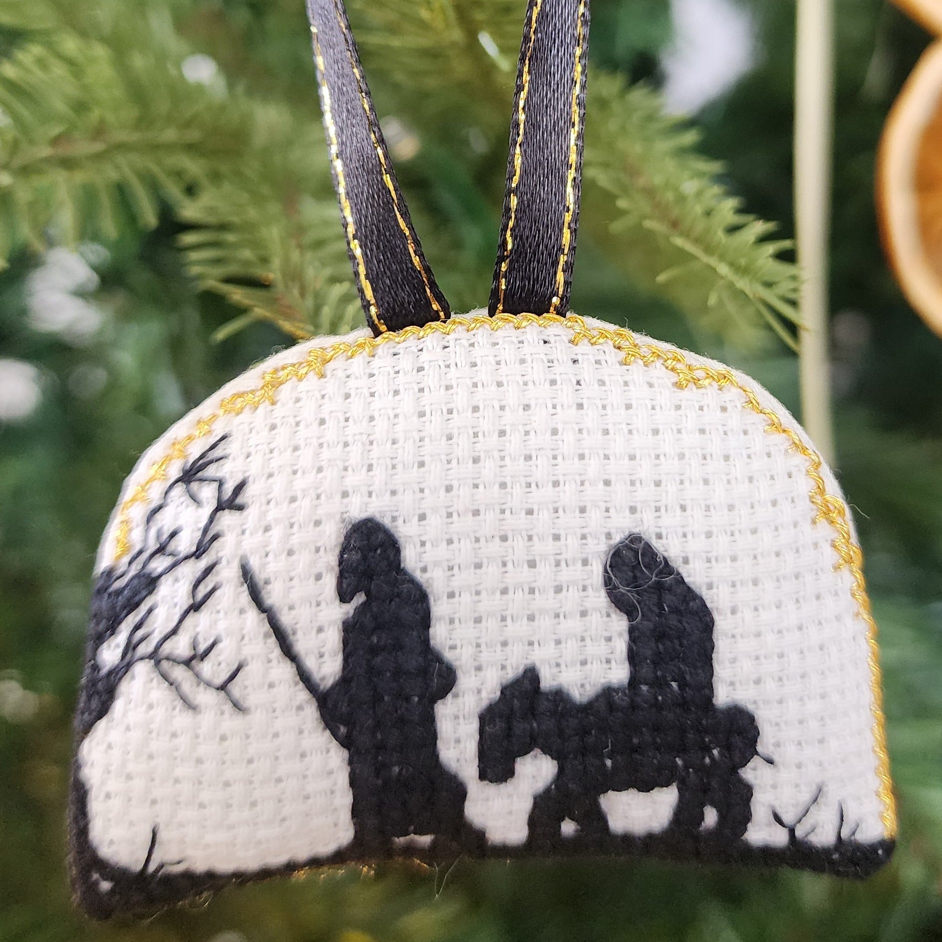 Decorative ornament with black and white design of Mary and Joseph