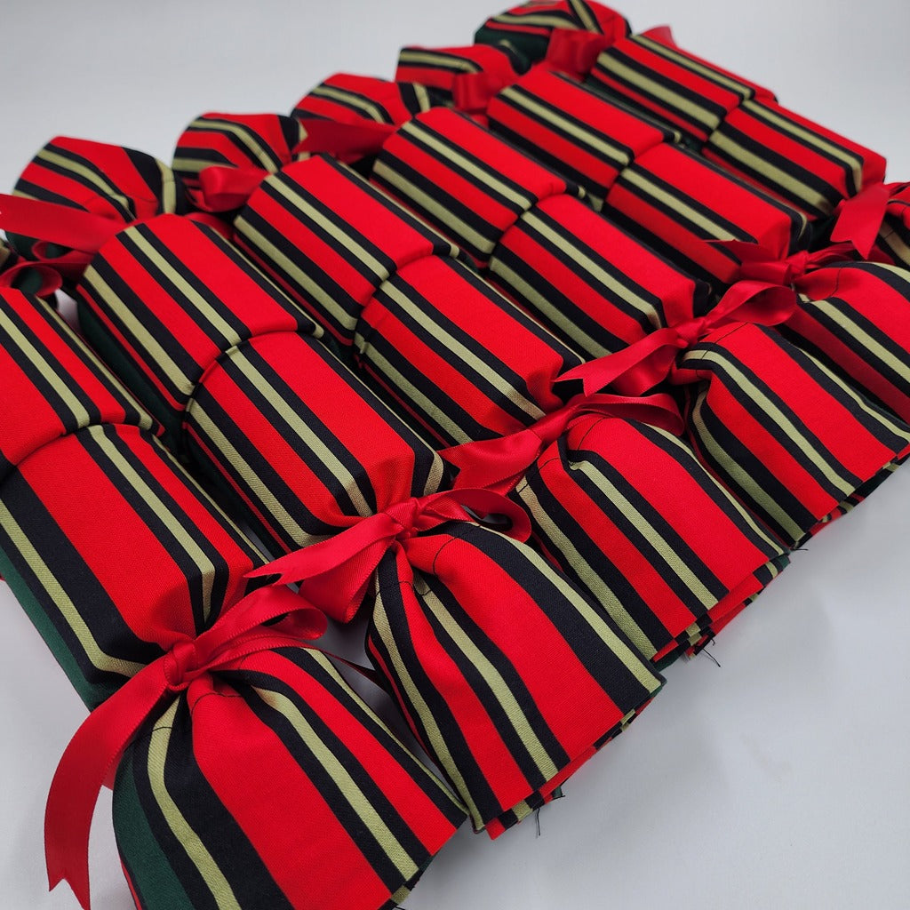 Red and green striped crackers with red ribbons on a white background