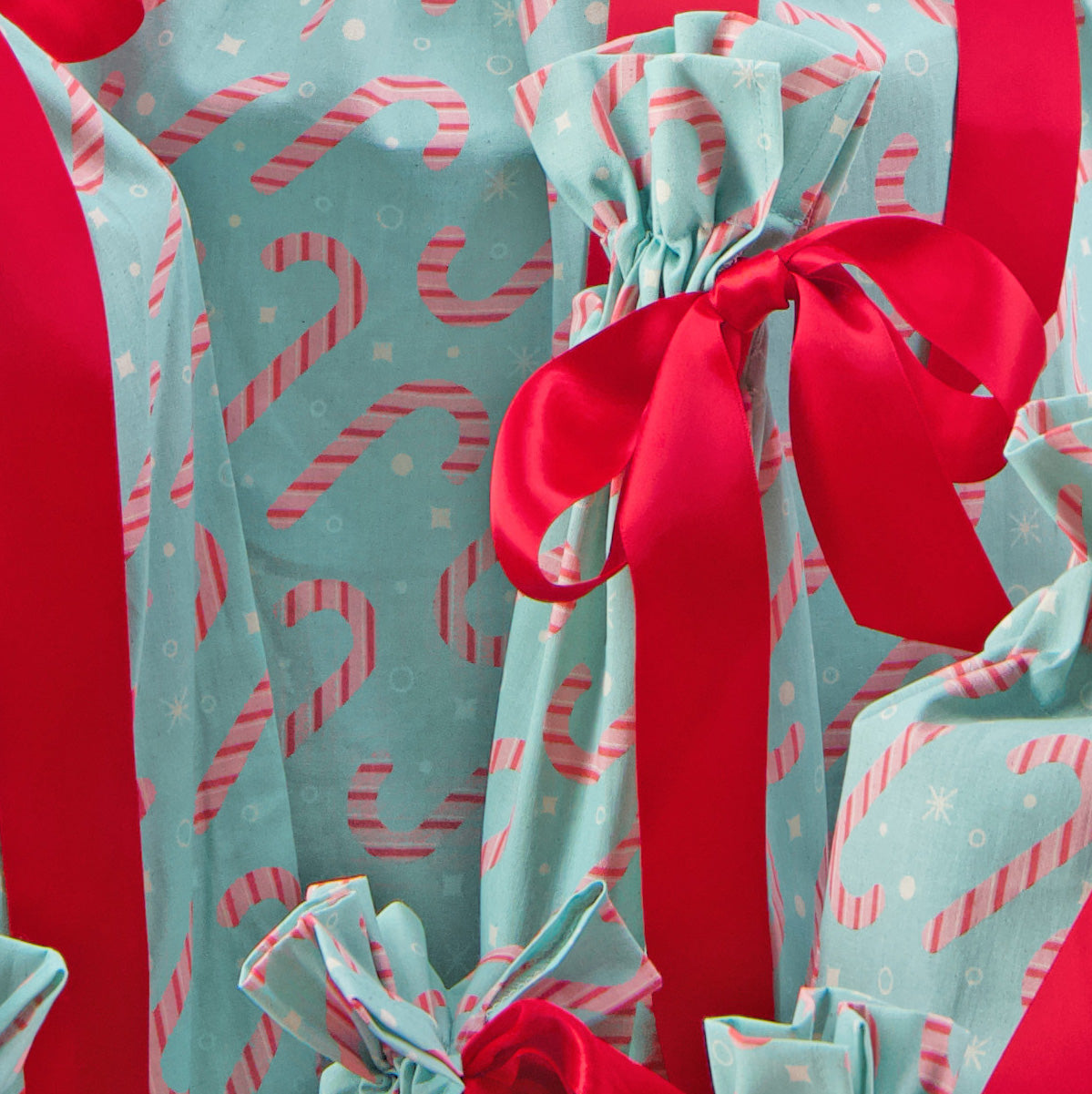 Dulces fabric close-up — candy cane print in pink and white on mint green