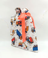 Large Hard Hats Required reusable gift bag. Fabric has drawings of dump trucks, on a white background. Bag is tied with orange ribbon.