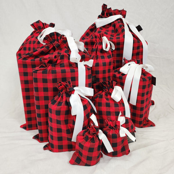 Set of ten reusable Christmas gift bags in American Plaid. Bags are black and red check with a white satin ribbon.