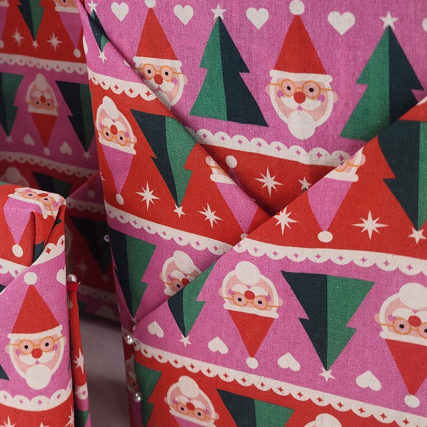 Furoshiki cotton gift wrap on on four gifts in red, pink, green and white santa design