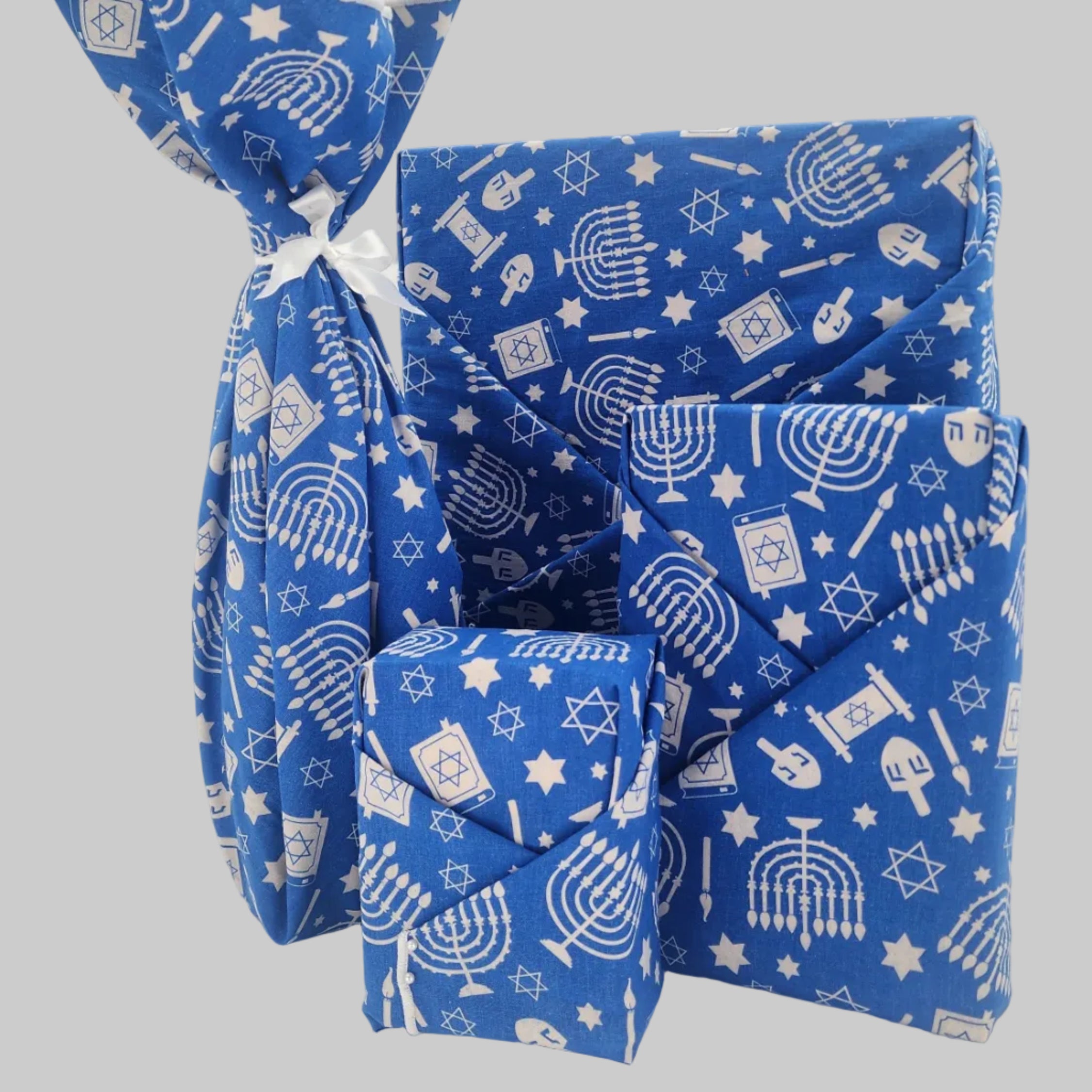 Furoshiki cotton gift wrap on on four gifts in blue and white Hanukkah design