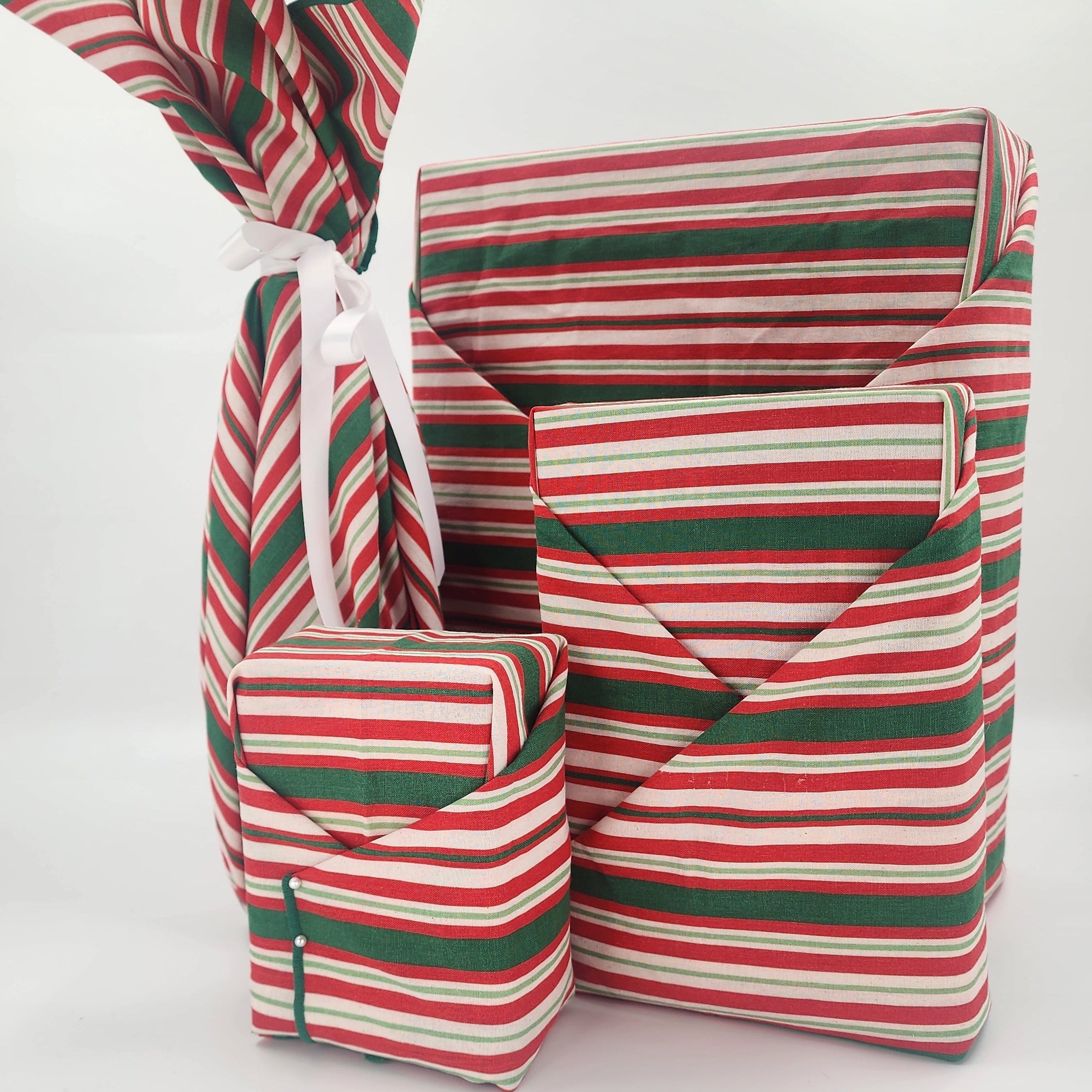 Furoshiki cotton gift wrap on on four gifts in red and green striped design