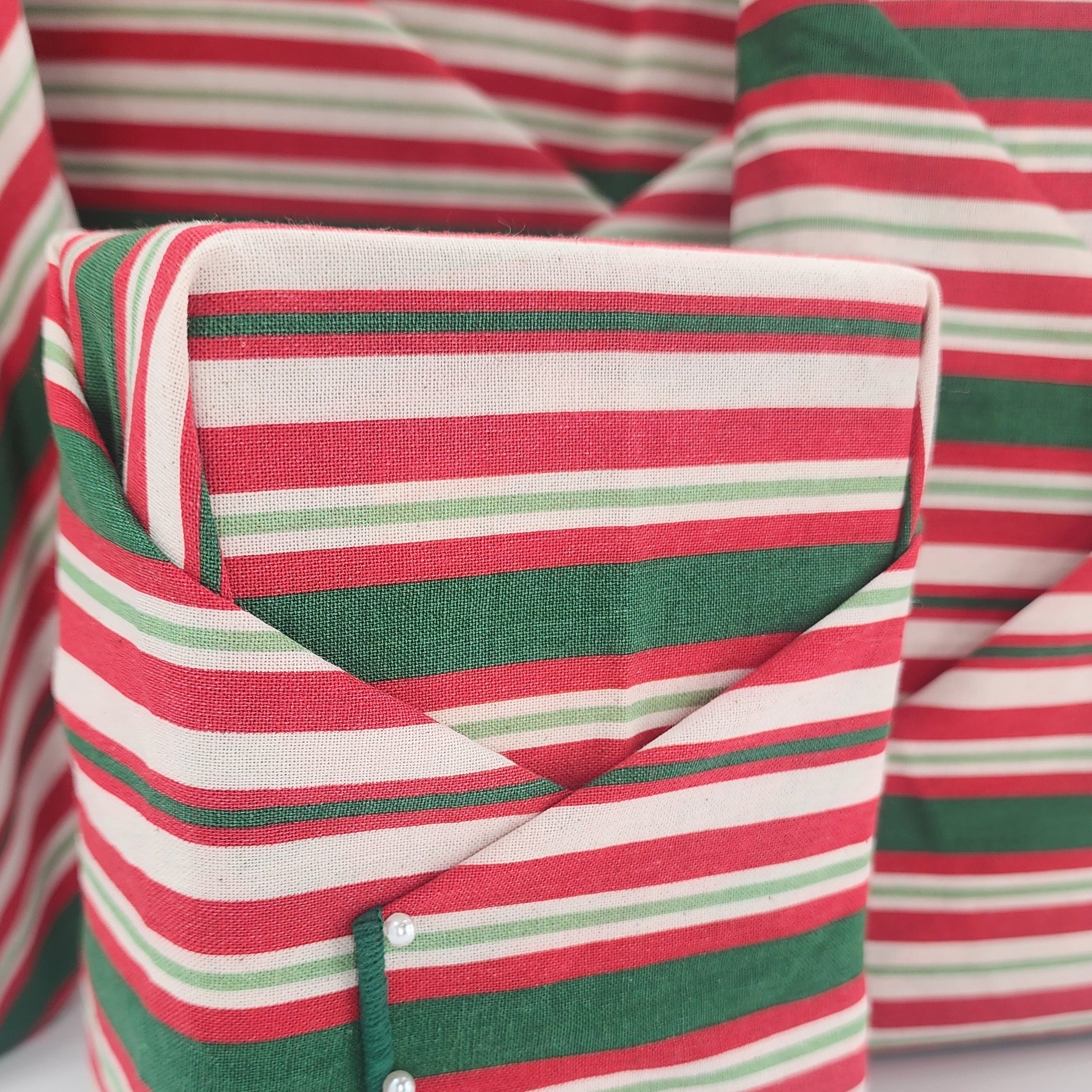 Furoshiki cotton gift wrap on on four gifts in red and green striped design