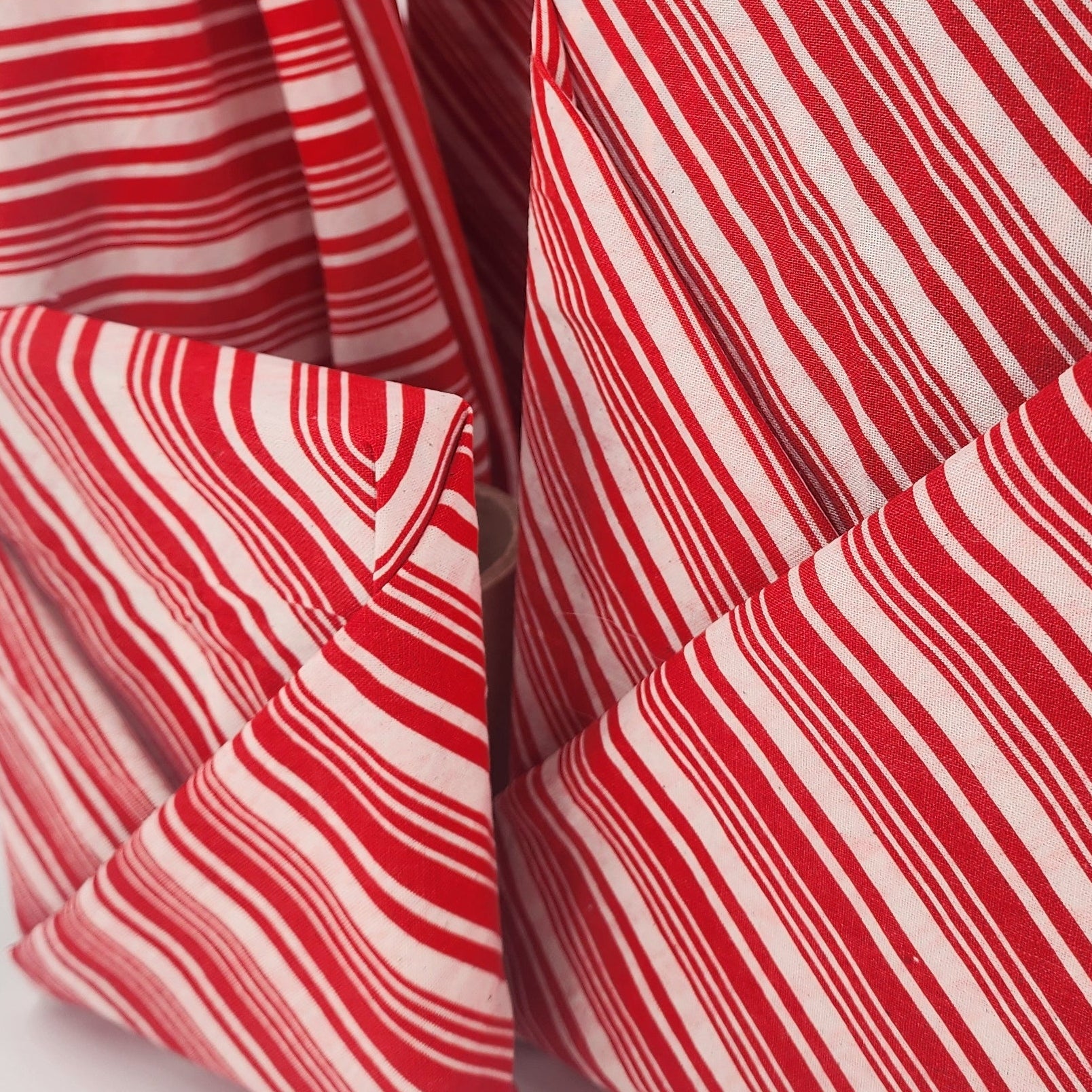 Furoshiki cotton gift wrap on on four gifts in red and white candy cane design