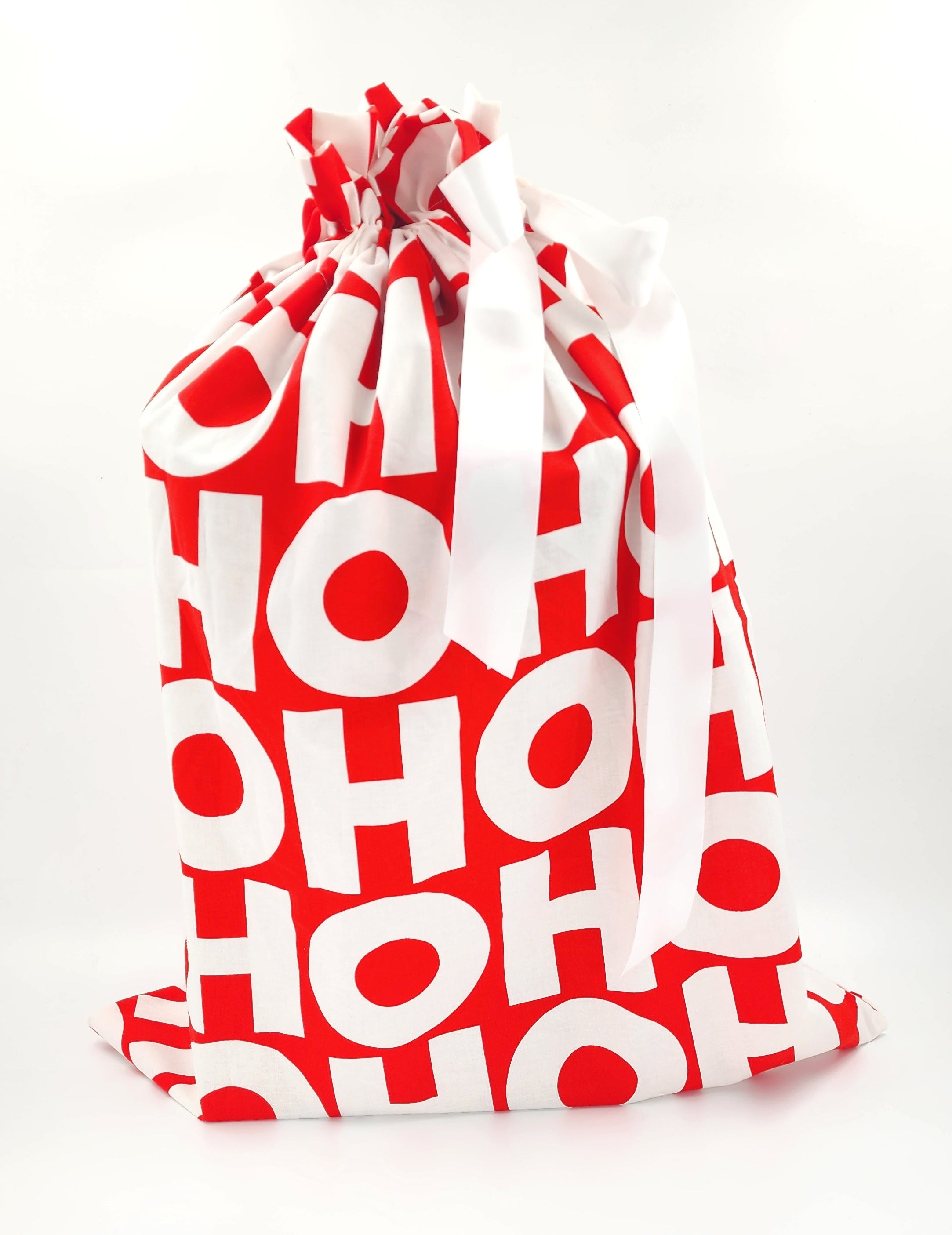 A red and white drawstring gift bag featuring a repeating 'HO HO HO' pattern, tied with a white ribbon on a white background.