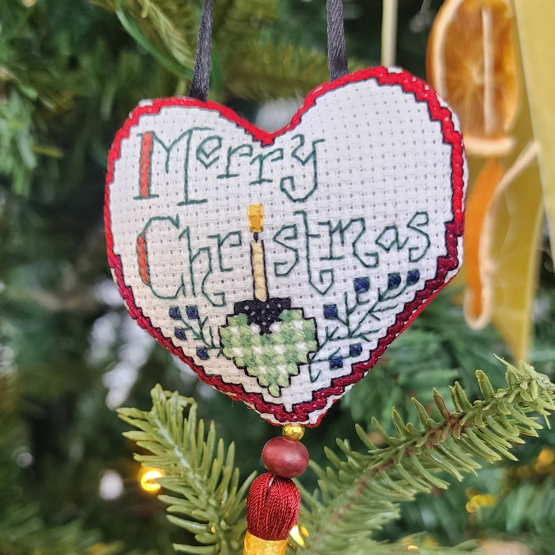 Cross stitched heart tree ornament with Merry Christmas and red tassle