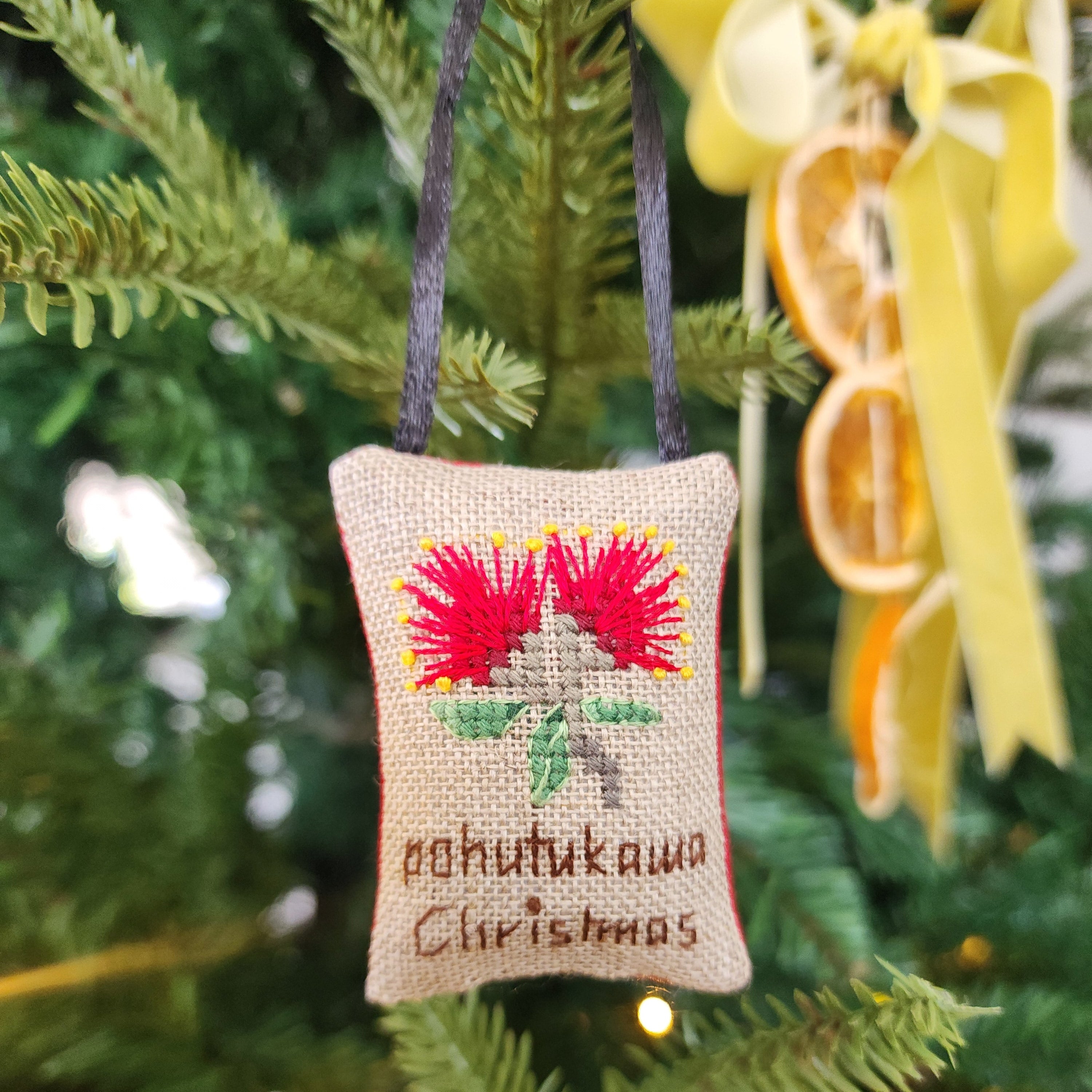 Decorative Christmas ornament with floral design on a Christmas tree.