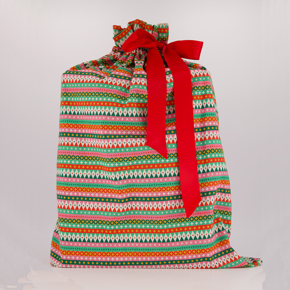 Santa Sack reusable gift bag — vibrant fiesta print in red, pink, green and gold — handmade in Afghanistan