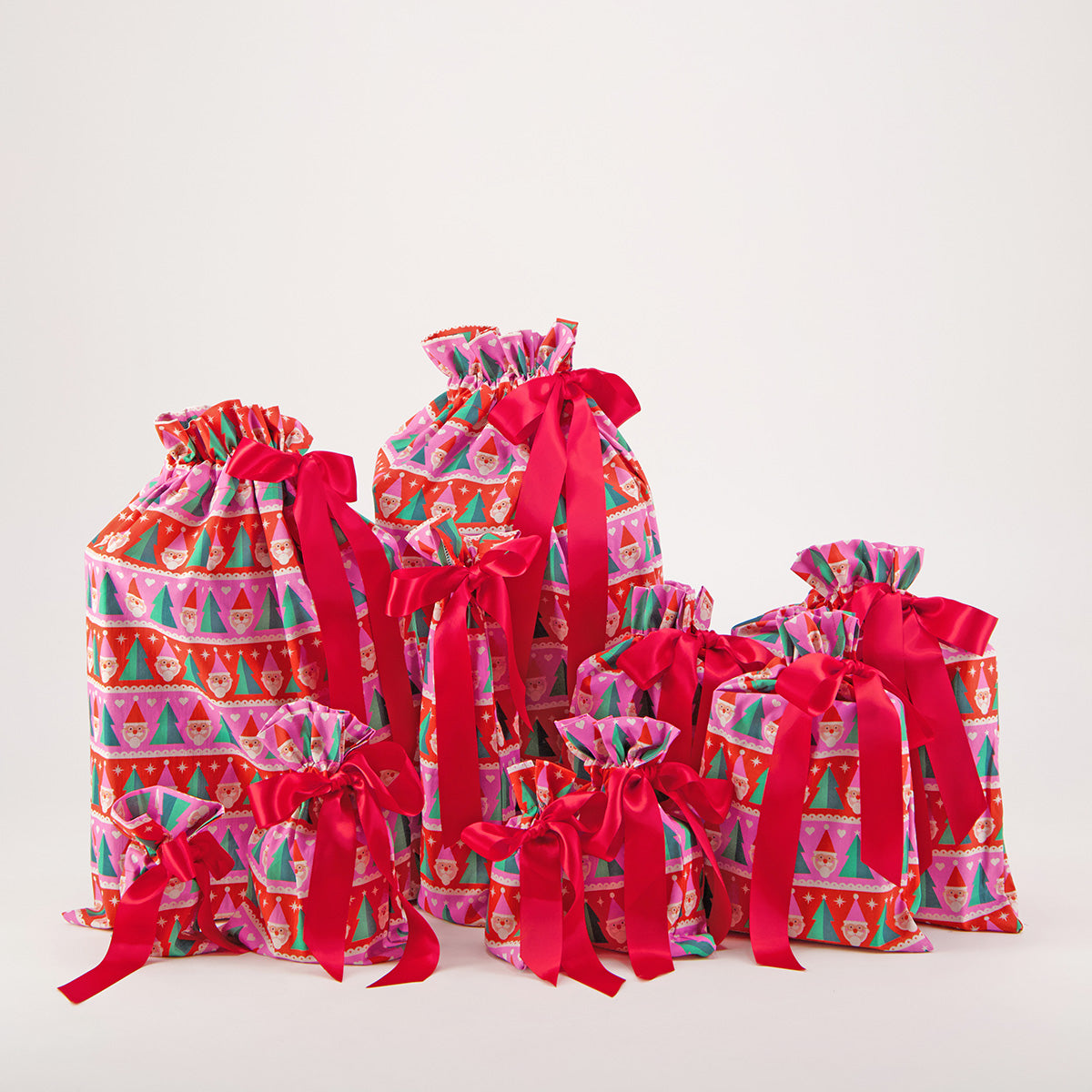 Papa Noel reusable gift bag set of 10 — Santa and Christmas tree print in bold pink, red and green — handmade in Afghanistan