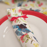Close up of Flora and Fauna Re-Crackers (reusable eco-friendly Christmas Crackers or Bon bons). This fabric features tui, kowhai and pohutakawa on a white background. Finished with red satin ribbons.