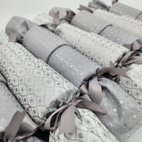 Silver and Ice Re-Crackers (reusable Christmas Crackers or Bon-Bons). Fabric has a sliver motif with alternating white and grey background with silver ribbon.