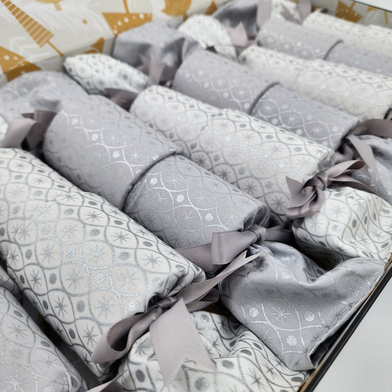 Boxed set of eight Silver and Ice Re-Crackers (reusable Christmas Crackers or Bon-Bons). Fabric has a sliver motif with alternating white and grey background with silver ribbon.
